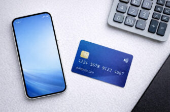 Как выбрать дебетовую карту: смартфон, банковская карта и калькулятор на рабочем столе