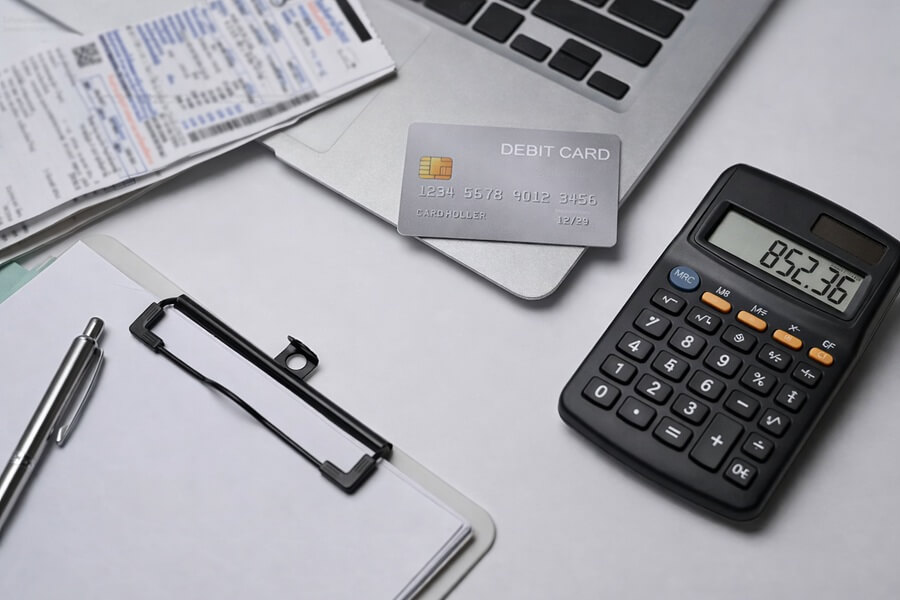 Калькулятор и банковская карта на столе - расчет кешбэка по карте